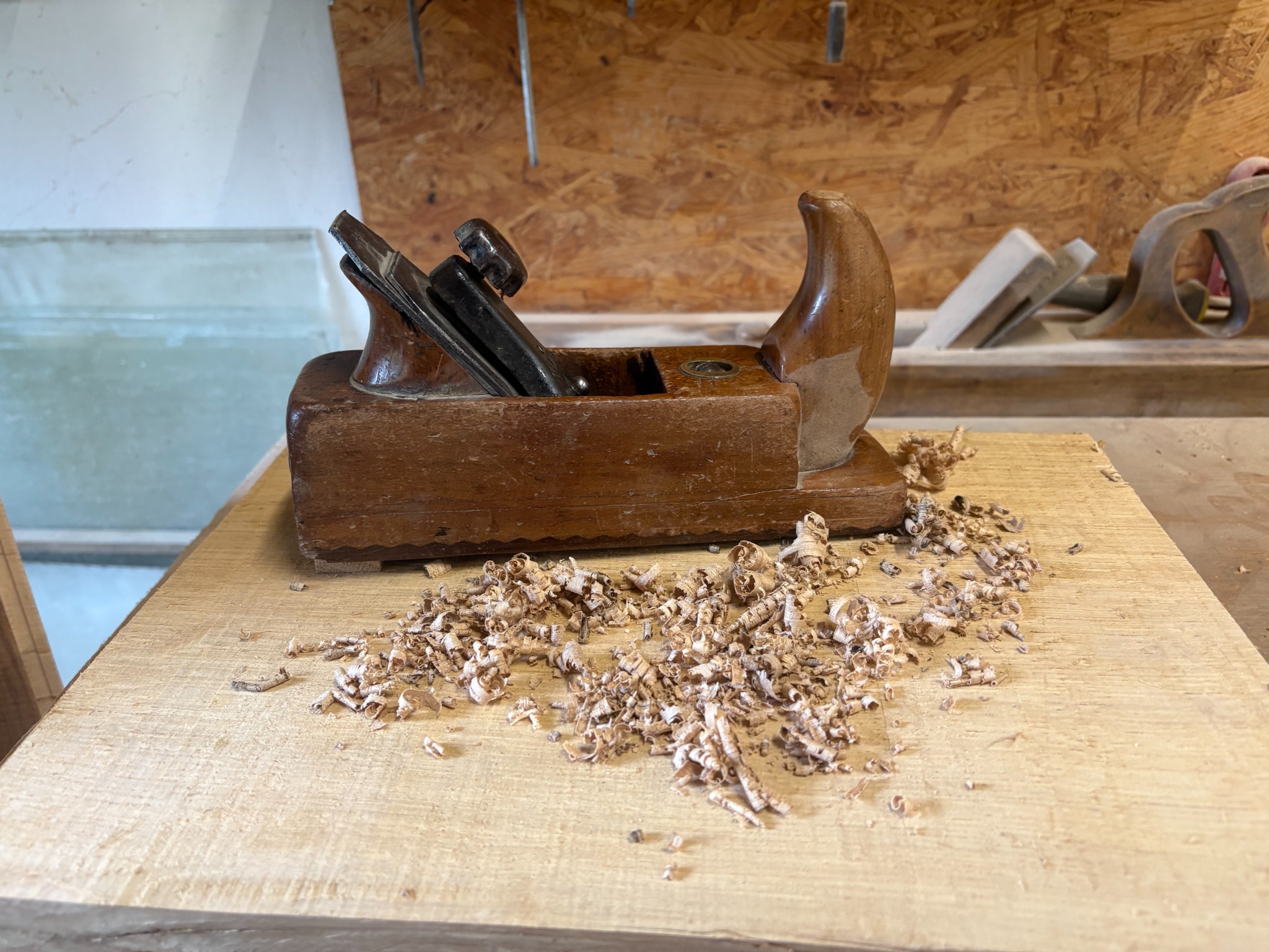 Hobel und Holzspäne auf einer Werkbank in der Tischlerei